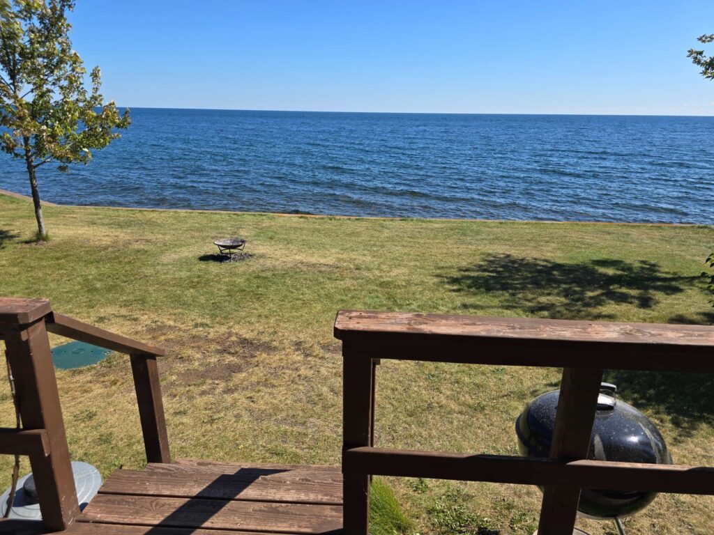 Open lawn running down to the Lake Superior shoreline at Ours Resort